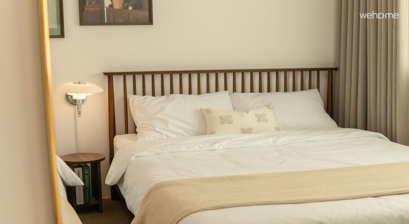 따뜻한 나무 톤과 깨끗한 흰색 침구가 밝고 아늑한 분위기를 완성합니다. 편안하게 쉴 수 있는 차분한 침실입니다Warm wood tones and clean white bedding complete a bright and cozy atmosphere. It is a calm bedroom where you can relax comfortably.