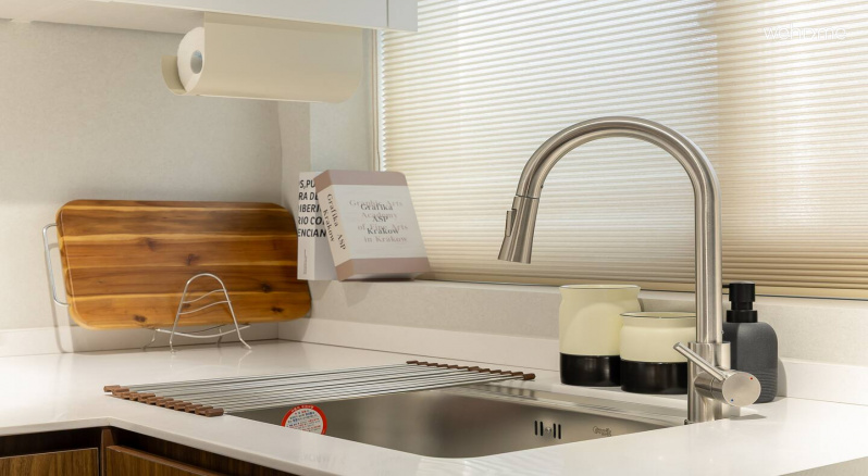 햇살이 비치는 주방 창과 정돈된 싱크대, 나무도마가 있는 주방에서 기분좋게 음식을 준비해보세요.Prepare food pleasantly in the kitchen with a sunny kitchen window, an organized sink, and a wooden cutting board.