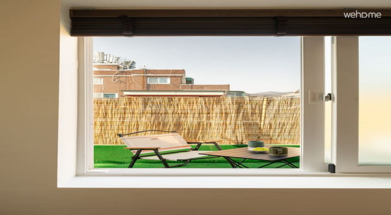 창문 너머 테라스의 캠핑 의자가 보이는, 실내외가 이어진 감성 공간입니다.There is a camping chair on the terrace beyond the window, which is an emotional space that connects indoor and outdoor.