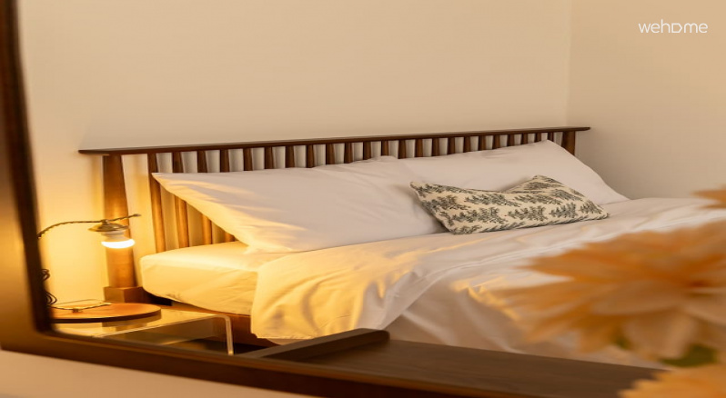 월넛 톤의 침대 옆에 은은한 조명이 있는 룸 2입니다. 정돈된 침구와 따뜻한 조명이 편안하고 아늑한 분위기를 만들어줍니다.Room 2 with subtle lighting next to a walnut-toned bed. Organized bedding and warm lighting create a comfortable and cozy atmosphere.