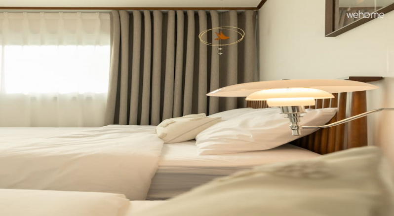 침대 옆 벽 조명이 공간을 부드럽게 밝혀주어 밤에도 아늑하고 편안한 분위기를 만들어줍니다. wall lighting next to the bed gently illuminates the space, creating a cozy and comfortable atmosphere even at night.