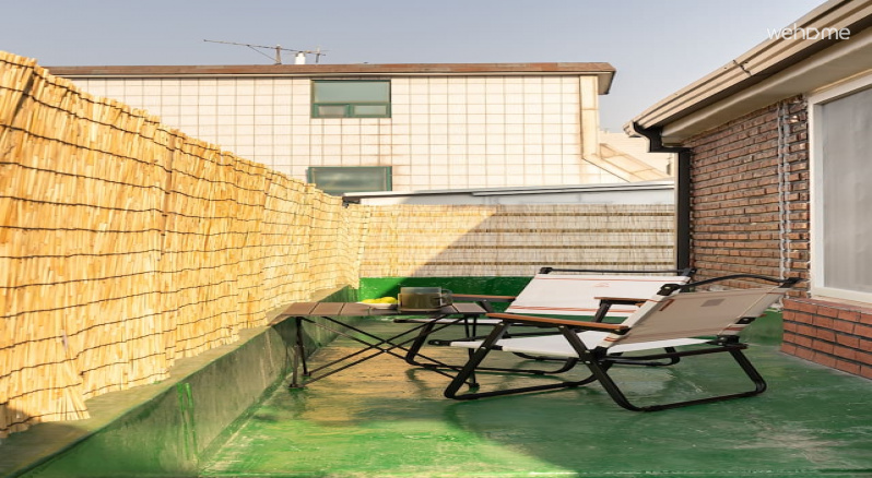 두 사람이 나란히 앉을 수 있는 캠핑 의자와 작은 테이블이 놓인 옥상 공간입니다. 낮에는 햇살을, 저녁에는 선선한 공기를 느끼며 머물 수 있는 아늑한 자리입니다.