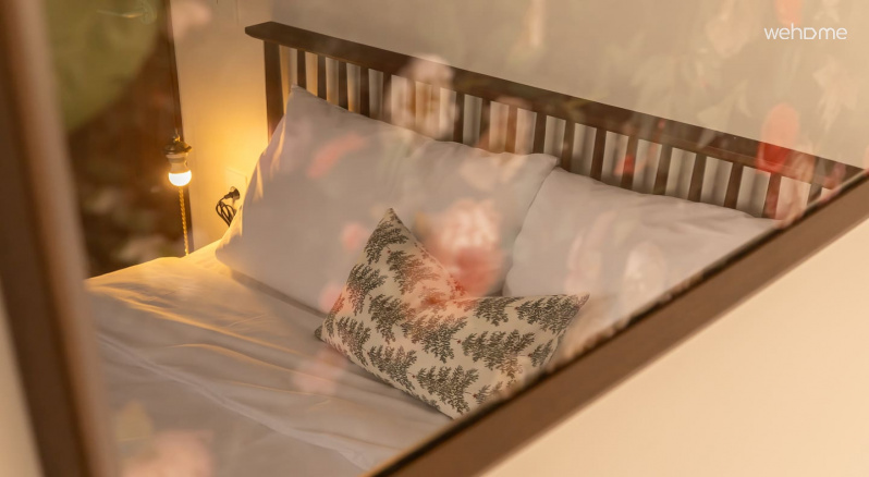 침대와 조명이 어우러져 공간에 부드럽고 따뜻한 분위기를 더합니다. The bed and lighting combine to add a soft, warm atmosphere to the space.