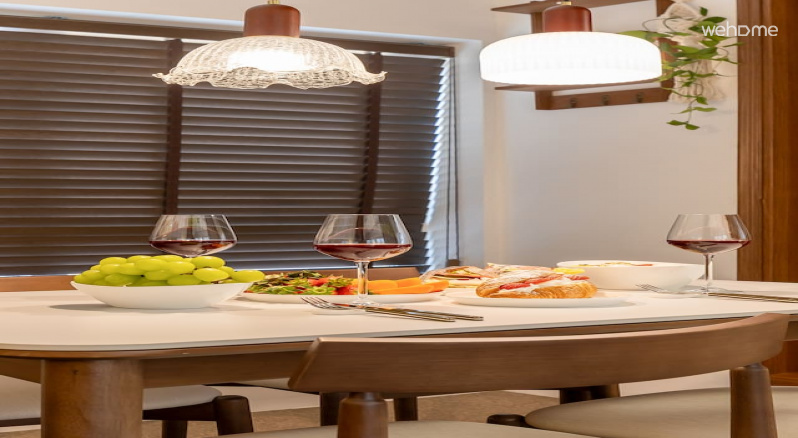 앤틱 조명이 은은하게 비추고, 월넛 톤 블라인드가 공간을 부드럽게 감싸는 다이닝 공간입니다It is a dining space with antique lighting gently illuminated and walnut-toned blinds gently wound around.
